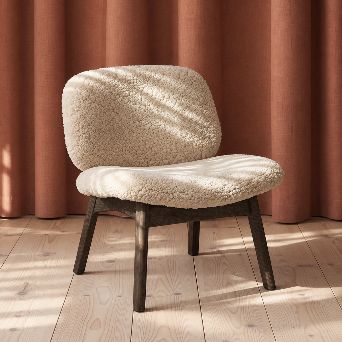 Loungestolen Pandora Lounge med blødt fåreskind, trædetaljer og rustrøde nuancer i et roligt skandinavisk design.