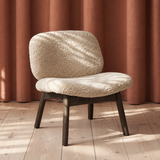 Loungestolen Pandora Lounge med blødt fåreskind, trædetaljer og rustrøde nuancer i et roligt skandinavisk design.